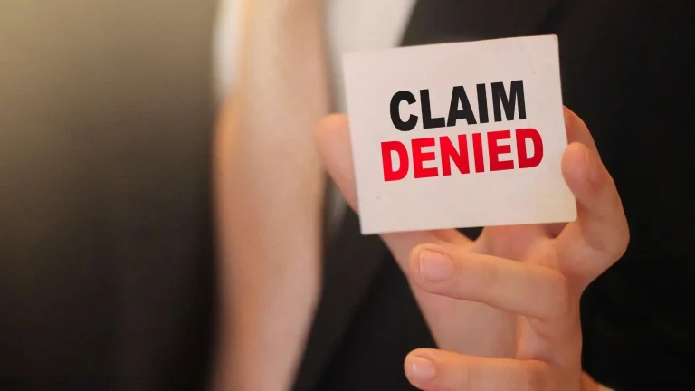 Worker holding a ‘claim denied’ sign representing what to do when your employer is fighting my workers comp claim and how to appeal the decision.