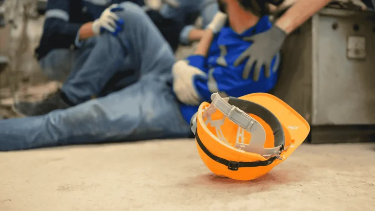 Construction worker injured on the job with safety helmet on the ground, showing when to hire an Oregon construction site accident lawyer for compensation.
